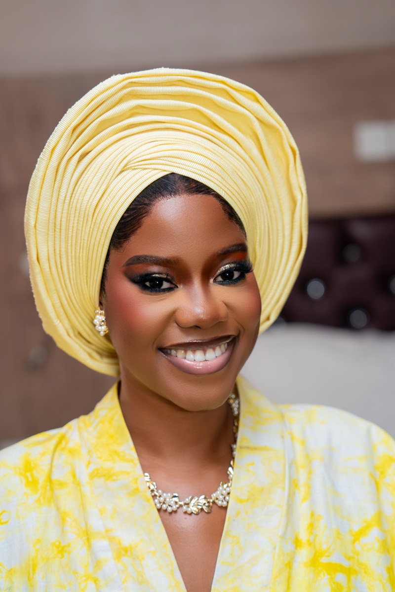Smiling bride in a yellow gele
